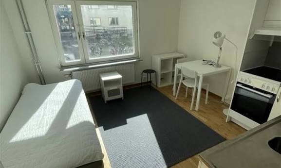 Furnished student accommodation room with a bed and study desk in Sweden